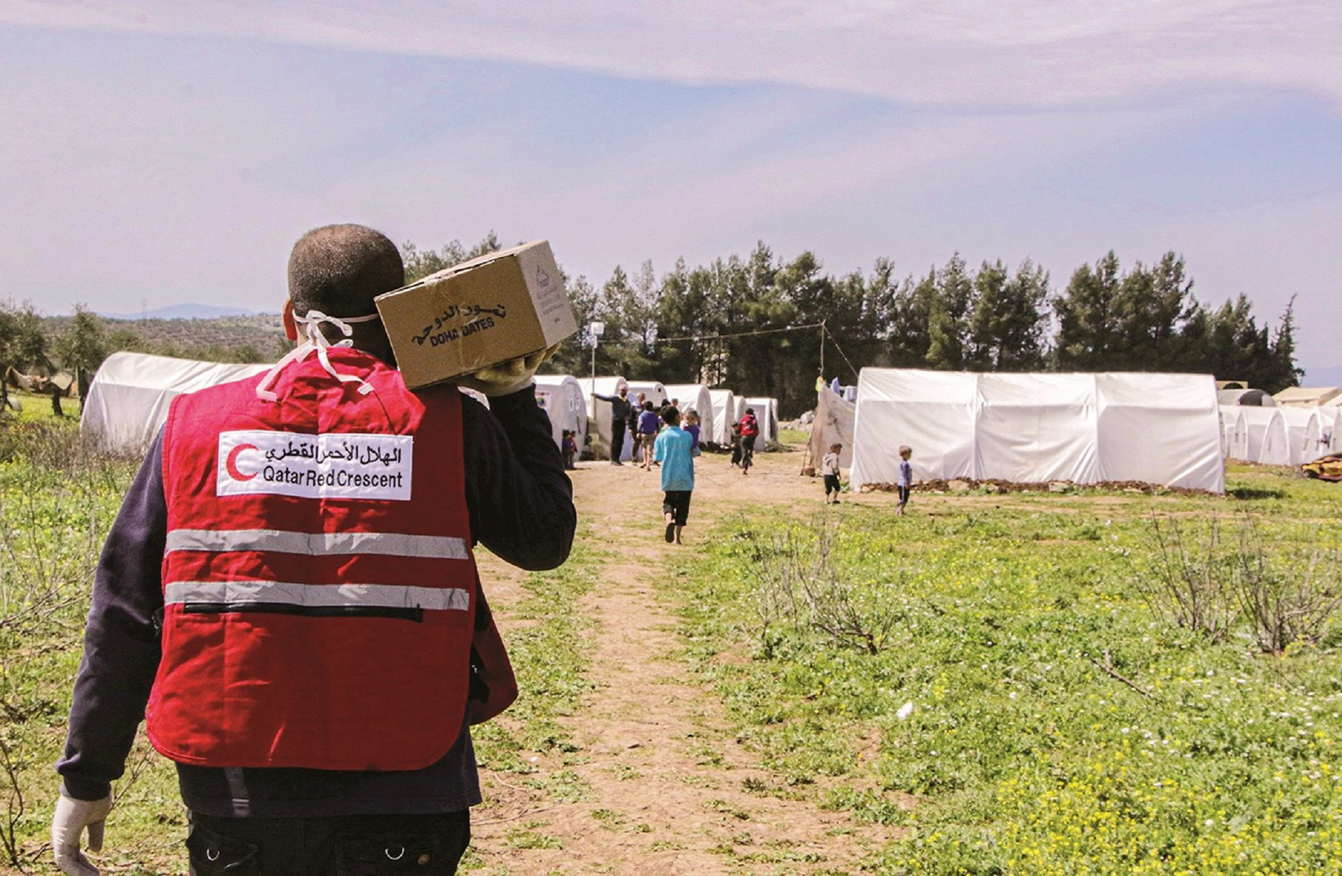 Qatar Red Crescent Employer holding food in a refugees camp